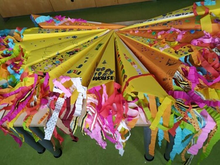 Viele gelbe Zuckertüten, mit bunten Kreppband-Fransen und Beschriftung.